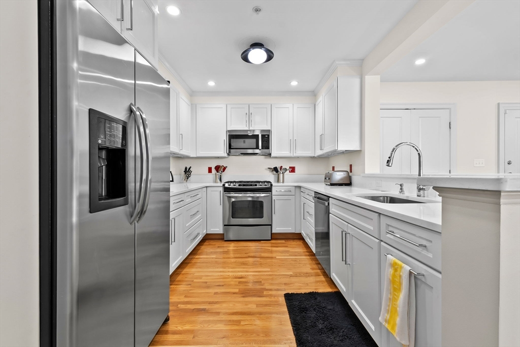 33 Intrepid Circle, Unit 208 Marblehead, MA 01945 - Photo 16 of 35 a kitchen with stainless steel appliances granite countertop a sink a stove a refrigerator cabinets and a kitchen island