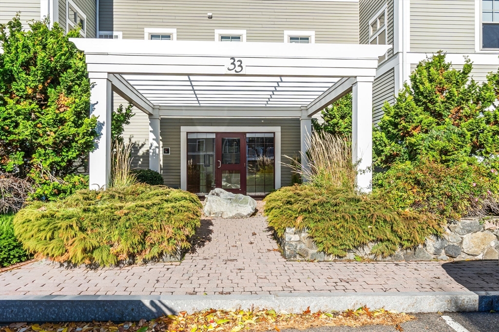 33 Intrepid Circle, Unit 208 Marblehead, MA 01945 - Photo 2 of 35 a view of a white house with large windows and potted plants