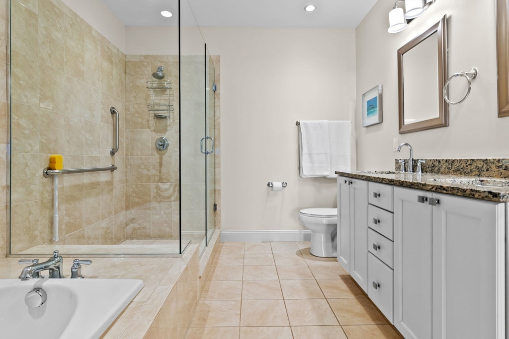 33 Intrepid Circle, Unit 208 Marblehead, MA 01945 - Photo 24 of 35 a spacious bathroom with a double vanity sink a toilet a mirror and shower