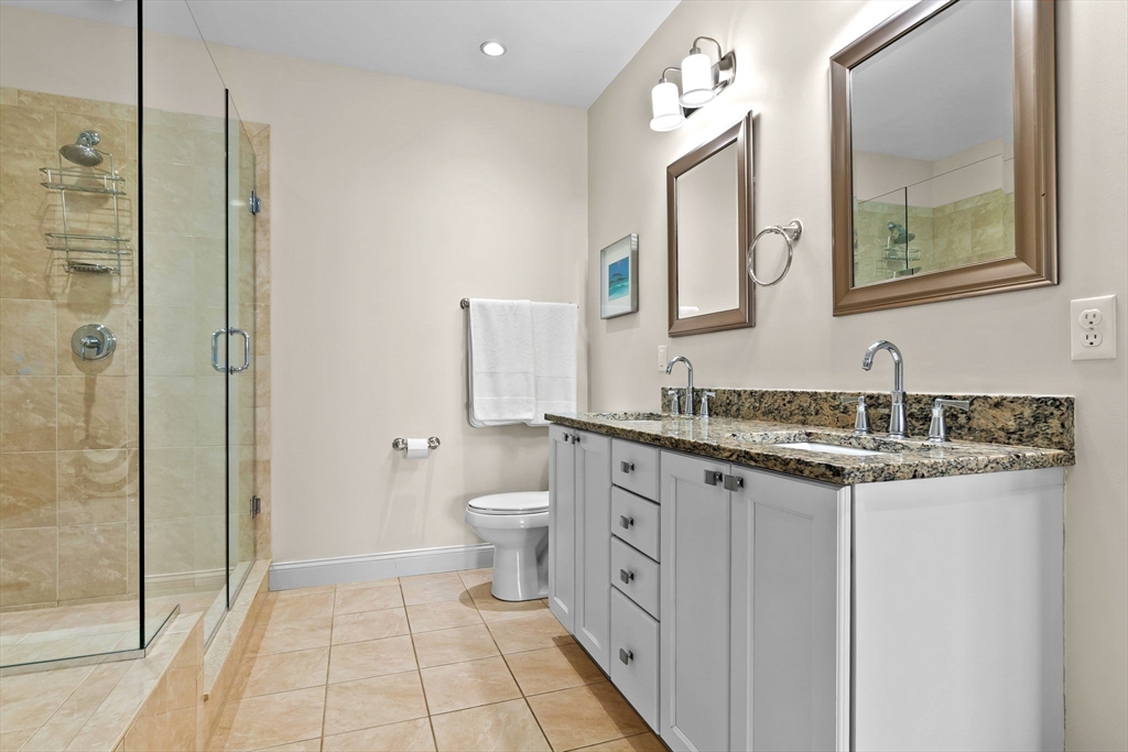 33 Intrepid Circle, Unit 208 Marblehead, MA 01945 - Photo 25 of 35 a bathroom with a granite countertop sink mirror and a toilet