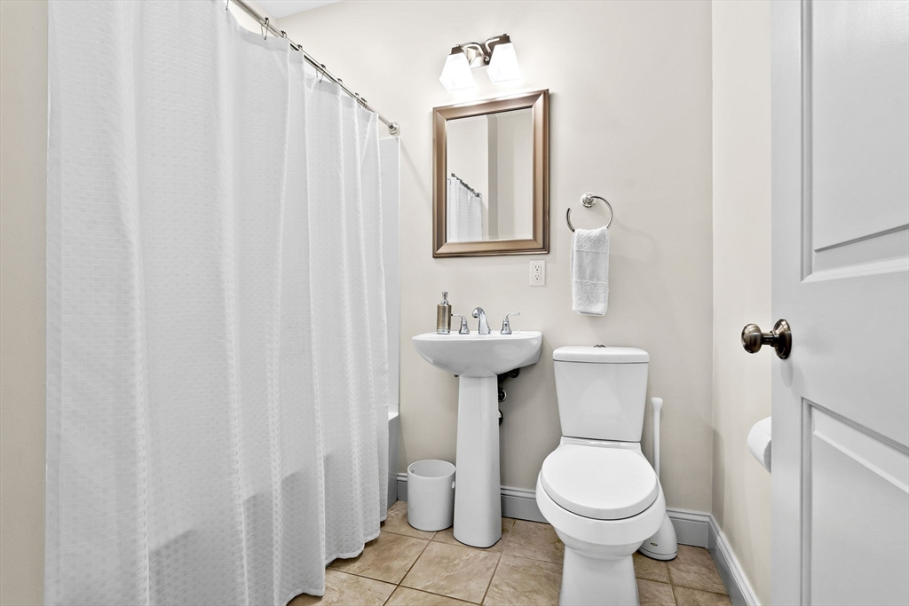 33 Intrepid Circle, Unit 208 Marblehead, MA 01945 - Photo 30 of 35 a bathroom with a sink a toilet and shower curtain