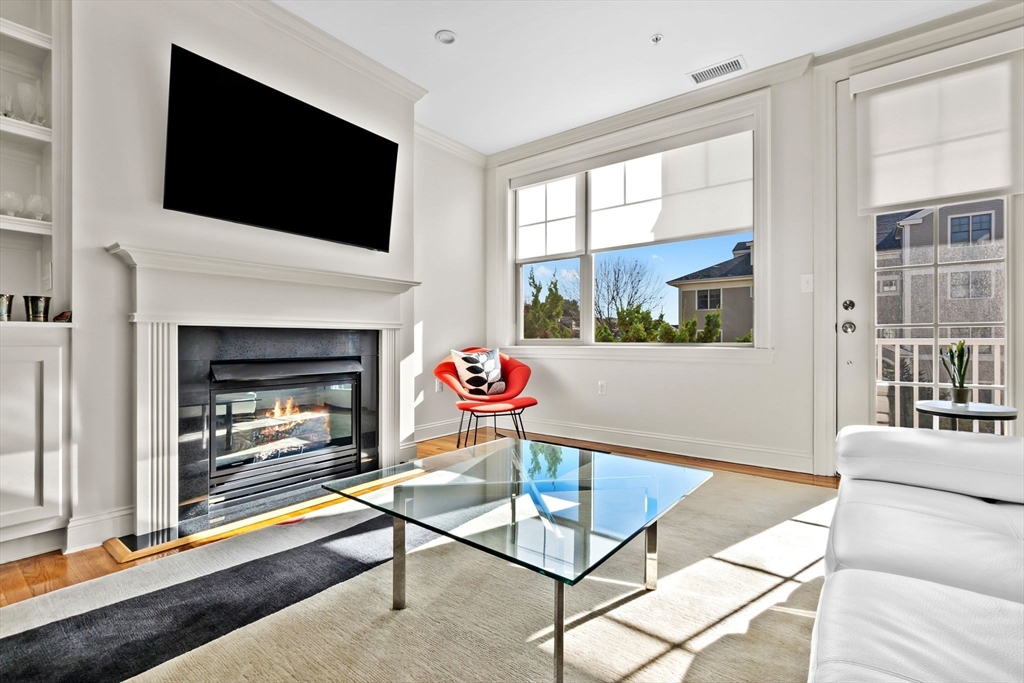33 Intrepid Circle, Unit 208 Marblehead, MA 01945 - Photo 9 of 35 a living room with a fireplace and a flat screen tv