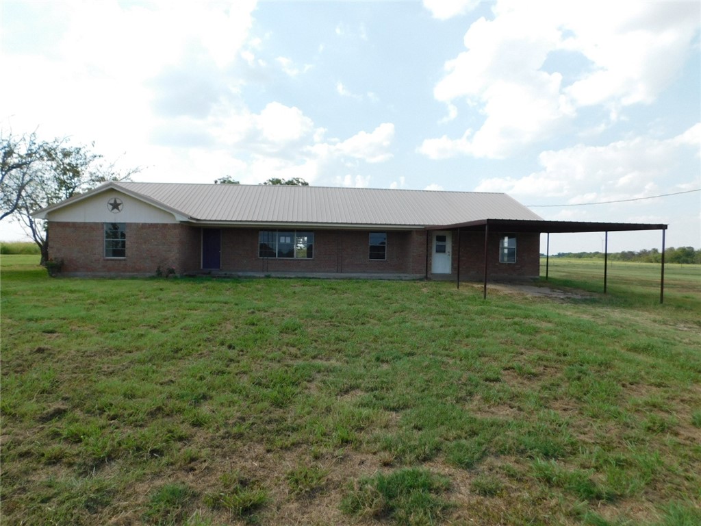 a view of a house with a yard and sitting area