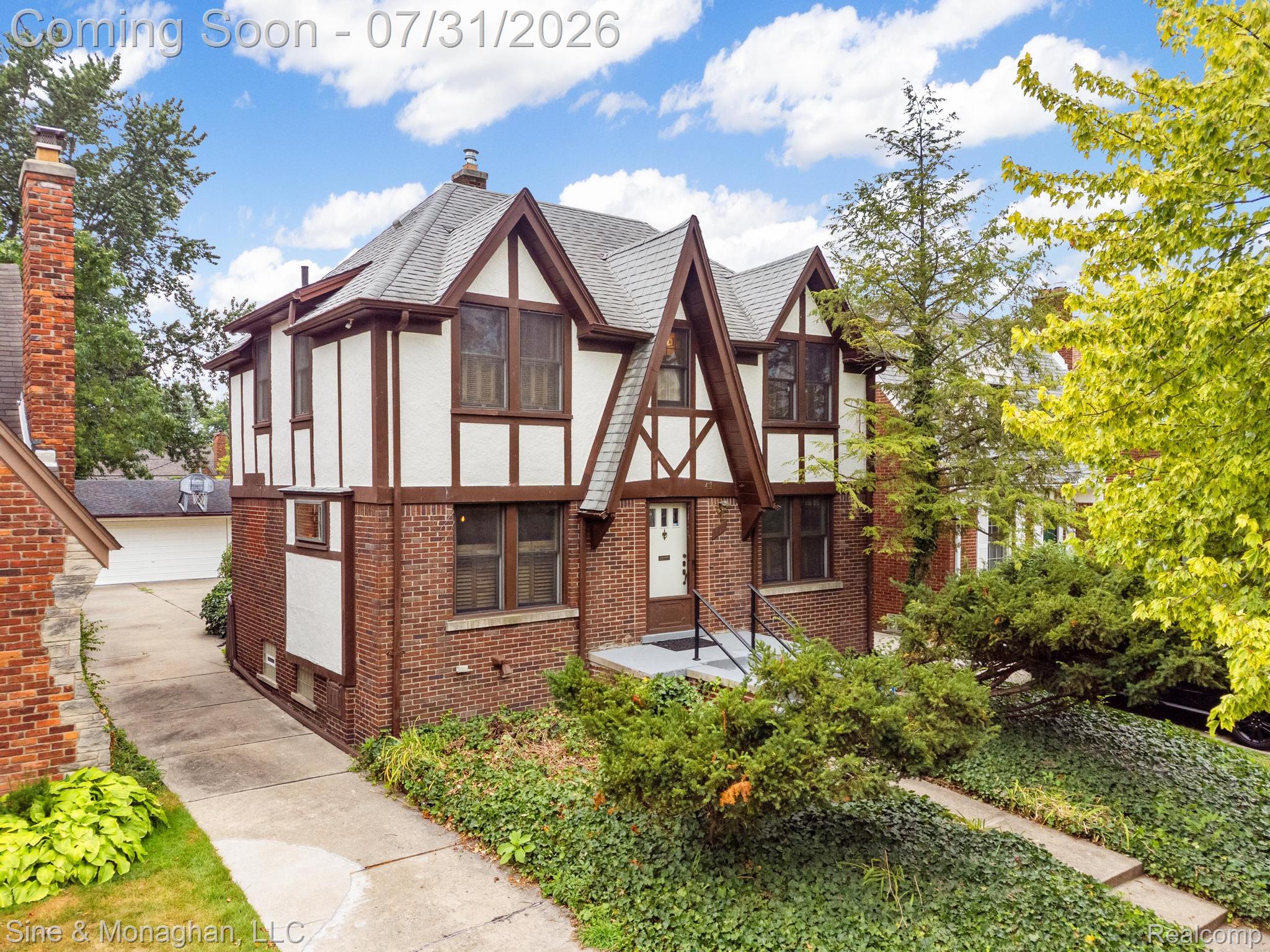 Tudor Revival exterior featuring a pitched roof, brick lower level, and half-timbered upper facade
