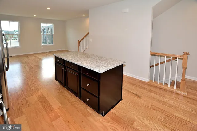 a kitchen with a sink a window and wooden floor