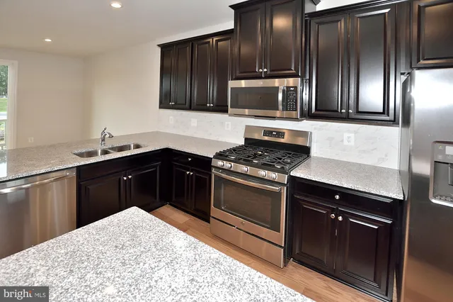 a kitchen with granite countertop stainless steel appliances and wooden cabinets