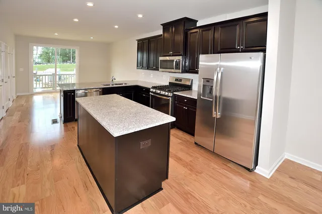 a kitchen with stainless steel appliances a refrigerator and a stove top oven