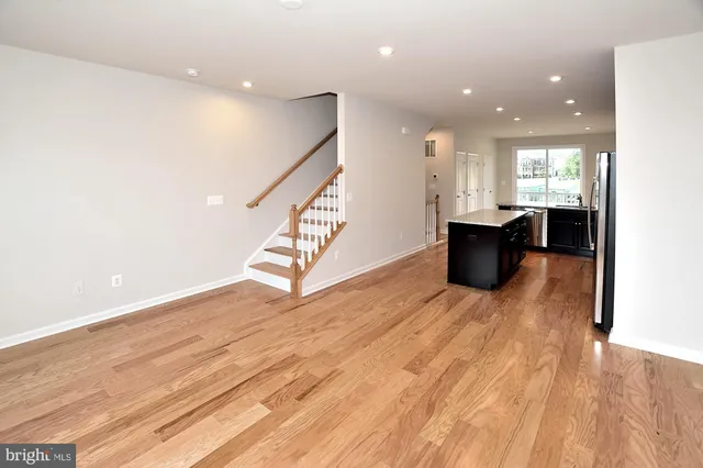 a view of entryway and kitchen with wooden floor