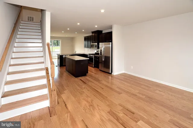 a view of a kitchen with wooden floor and stairs