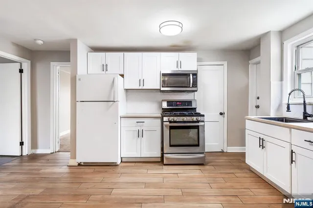 a kitchen with stainless steel appliances a refrigerator stove and white sink