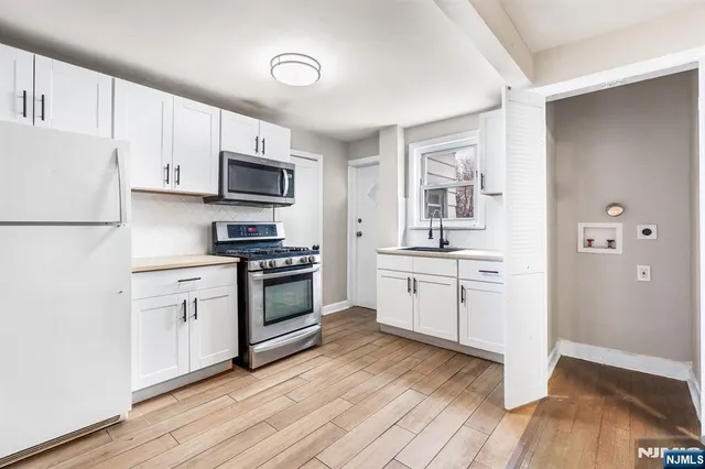 a kitchen with granite countertop white cabinets and stainless steel appliances