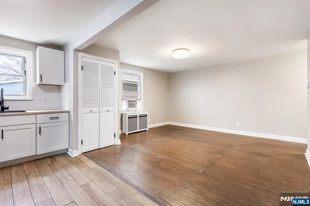 a view of a kitchen with wooden floor and a sink