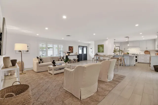a living room with furniture and kitchen view
