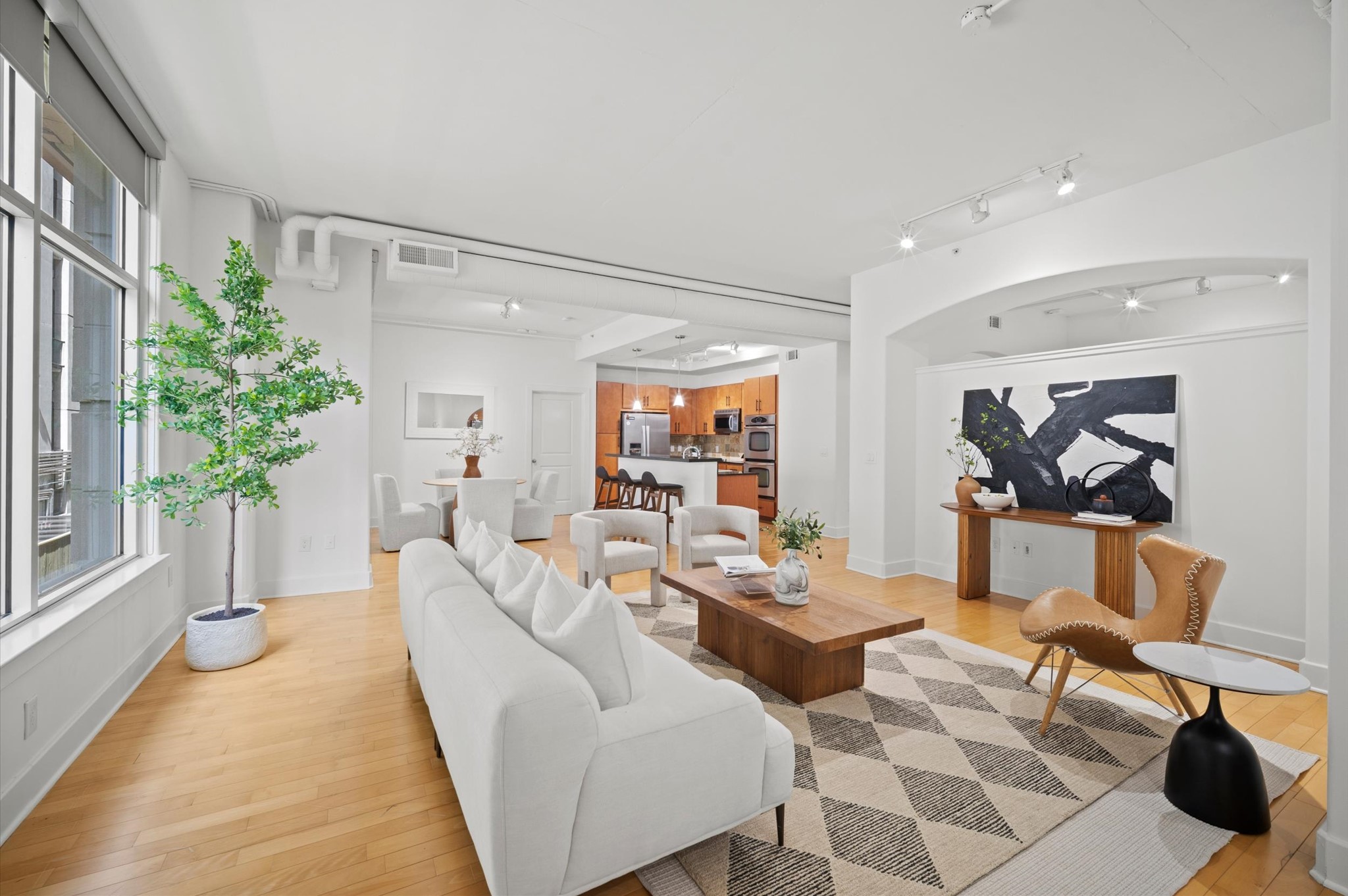 1901 Post Oak Boulevard, Unit 204 Houston, TX 77056 - Photo 15 of 36 Open, airy, and effortlessly sophisticated, with soaring ceilings, oversized windows, and a seamless flow to the dining and kitchen areas.