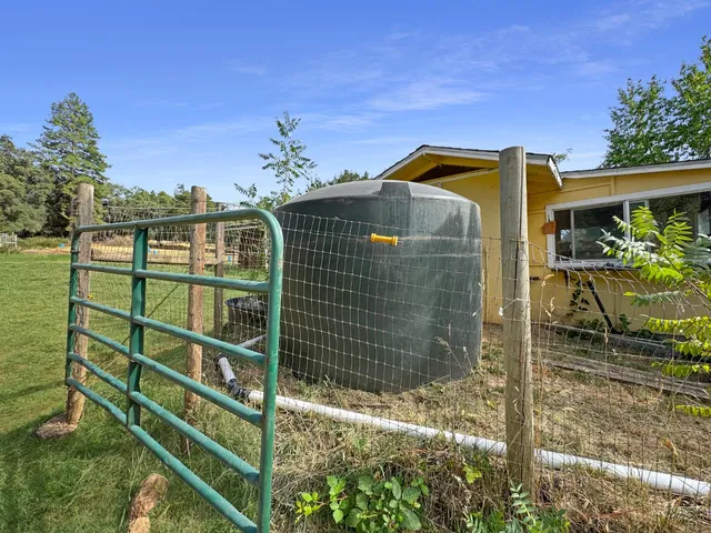 a view of swimming pool with outdoor seating and trees in the background