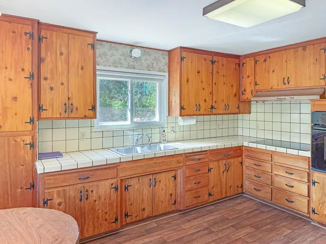 a kitchen with stainless steel appliances wooden floors and wooden cabinets