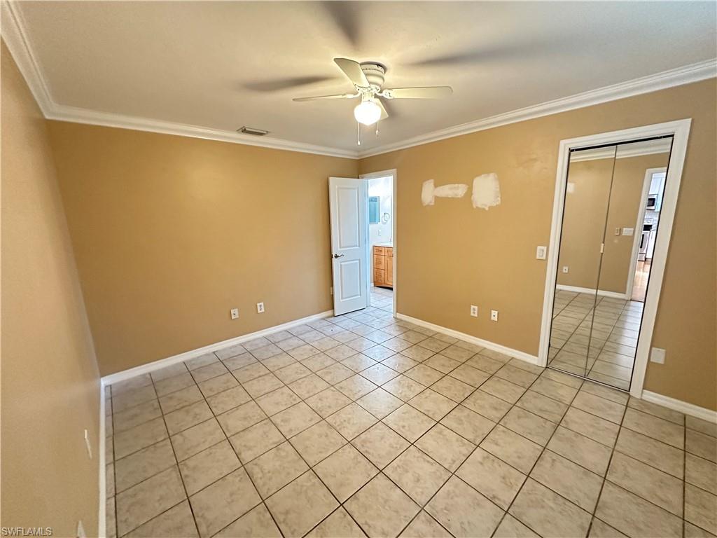 17436 Ingram Road Fort Myers, FL 33967 - Photo 7 of 18 Interior room featuring neutral-toned tile flooring, crown molding, and a ceiling fan with integrated lighting