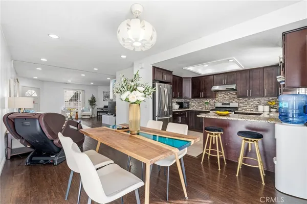 a view of a dining room and livingroom with furniture wooden floor a chandelier