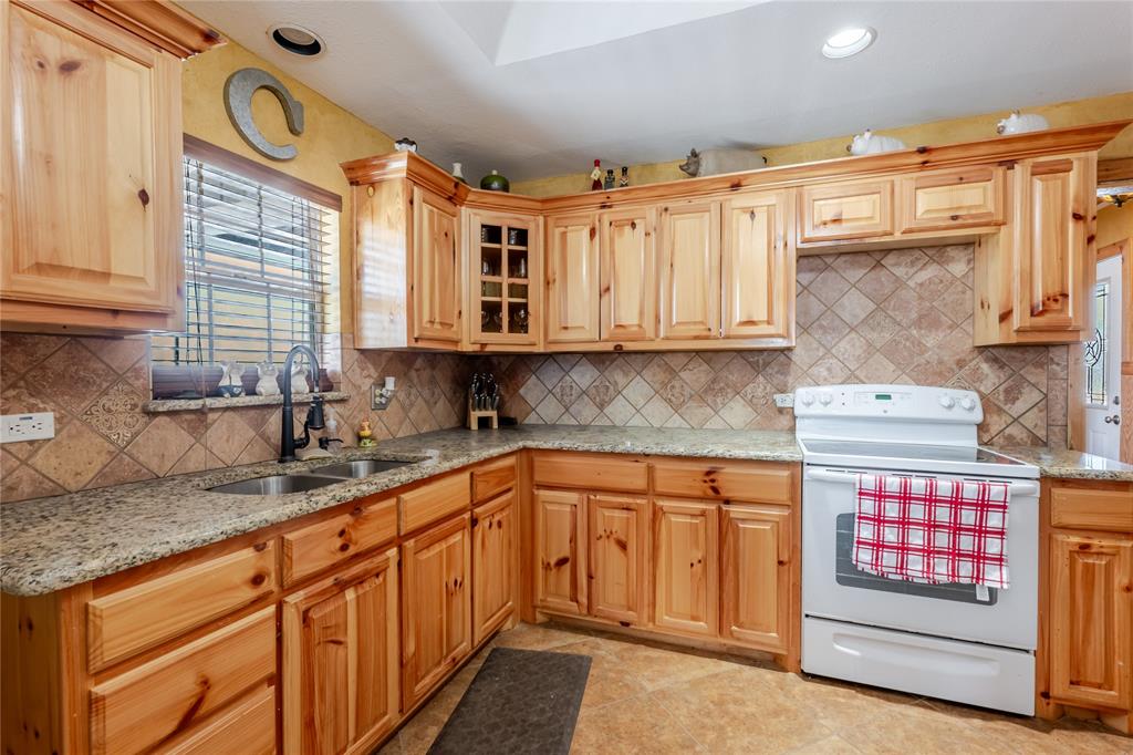 794 West Antelope Road, Unit 1 Windthorst, TX 76389 - Photo 11 of 40 a kitchen with stainless steel appliances granite countertop a sink dishwasher stove and cabinets