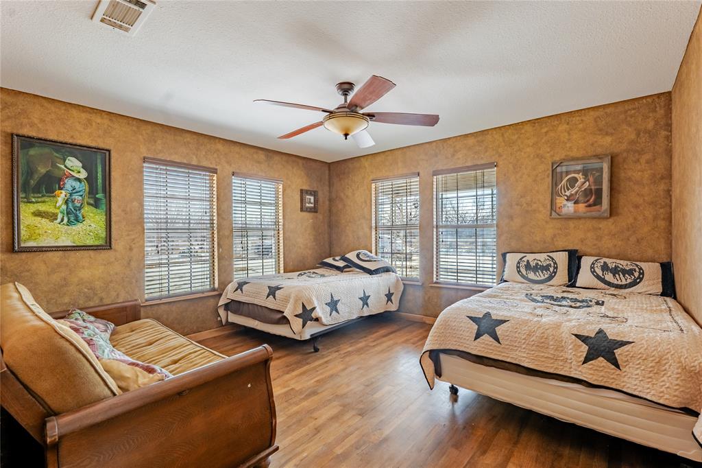 794 West Antelope Road, Unit 1 Windthorst, TX 76389 - Photo 14 of 40 a bedroom with two beds and a chandelier