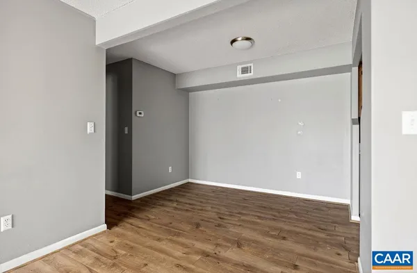 a view of an empty room with wooden floor