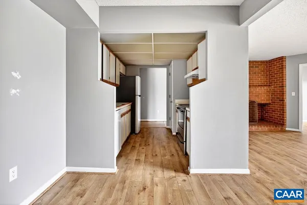 a view of a hallway with wooden floor and staircase