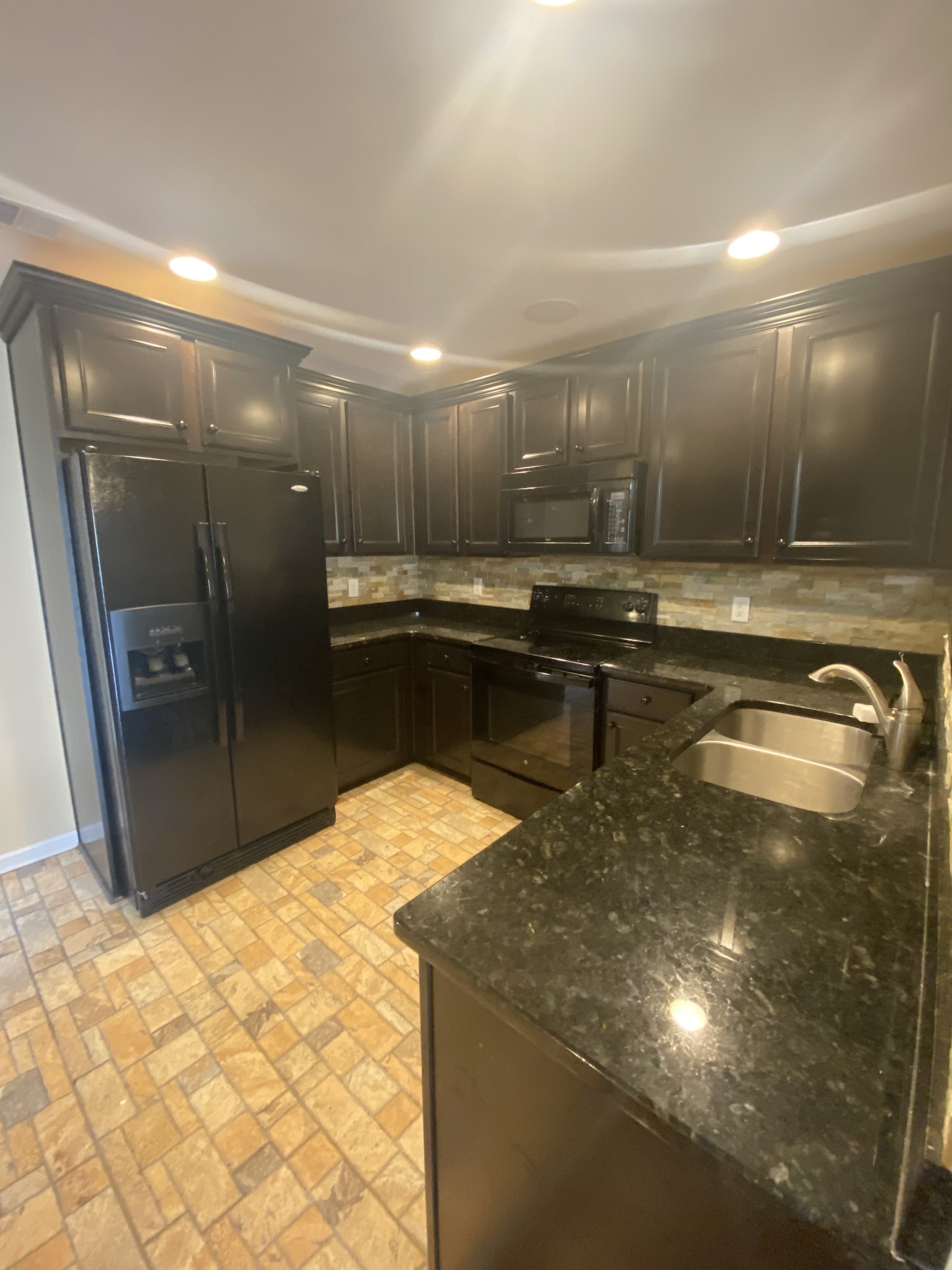 1437 Riverbrook Drive Hermitage, TN 37076 - Photo 7 of 16 a kitchen with stainless steel appliances granite countertop a sink and a stove top oven