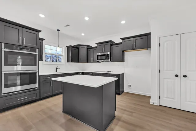 a kitchen with stainless steel appliances a stove sink and refrigerator