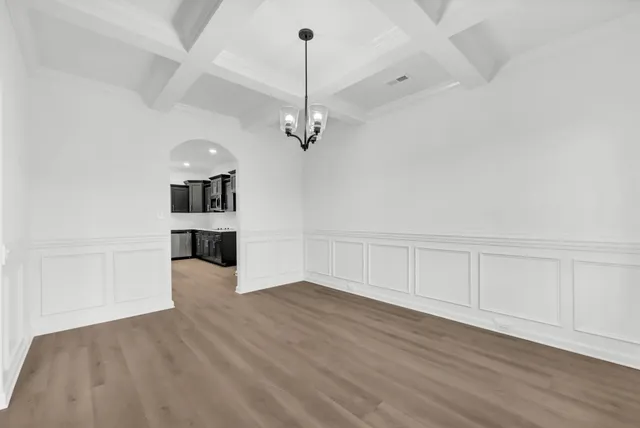 a view of a room with wooden floor and a ceiling fan