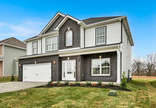 a front view of a house with a yard and garage