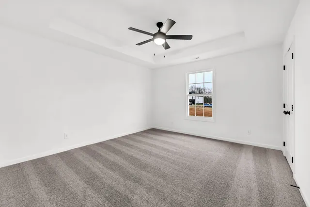 an empty room with fan and windows