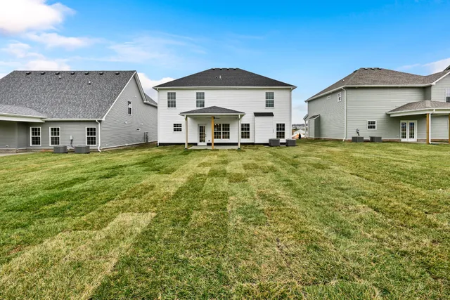 a view of a big house with a big yard and large trees