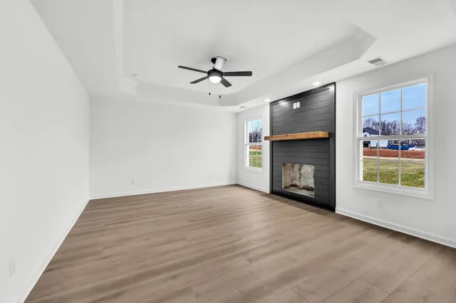 a view of an empty room with a fireplace and a window