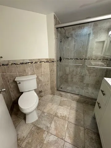 a bathroom with a toilet and a shower