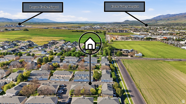 99 Penhurst Place Logan, UT 84341 - Photo 30 of 34 Aerial perspective showcasing a residential community with varied architectural styles, bordered by expansive green fields and distant mountains