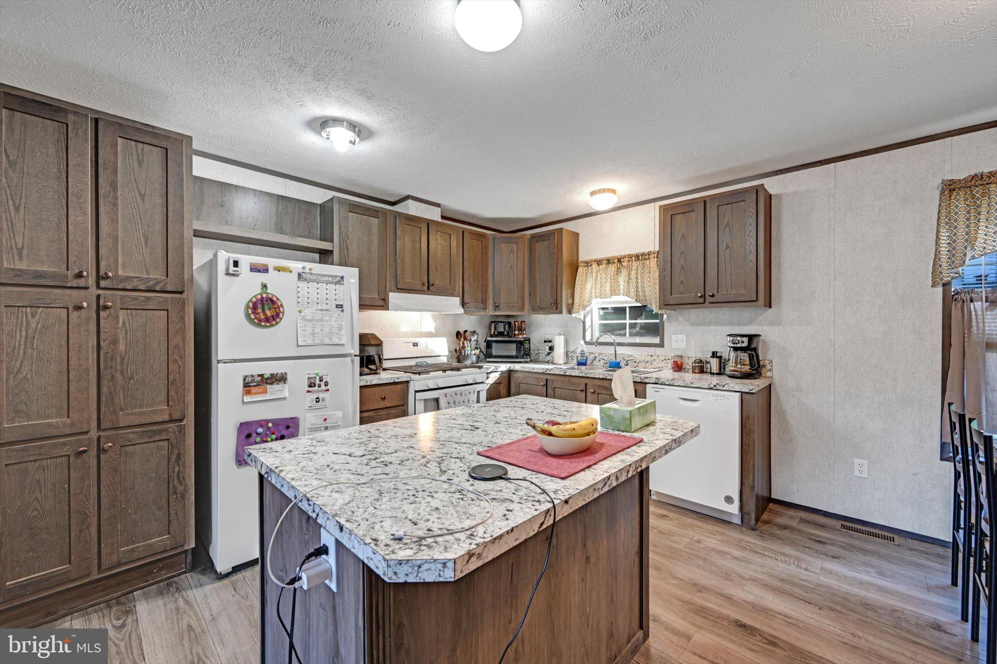 38 Squaw Circle Barto, PA 19504 - Photo 7 of 26 a kitchen with a refrigerator a stove a sink dishwasher and a refrigerator with wooden floor