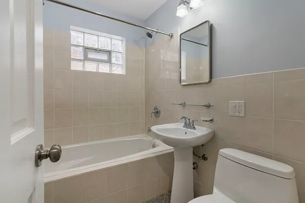 a bathroom with a sink mirror bathtub and toilet