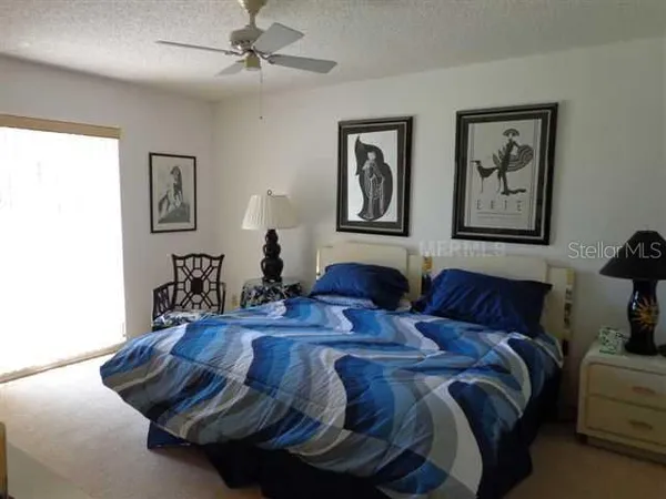 a bedroom with a bed and paintings on the wall
