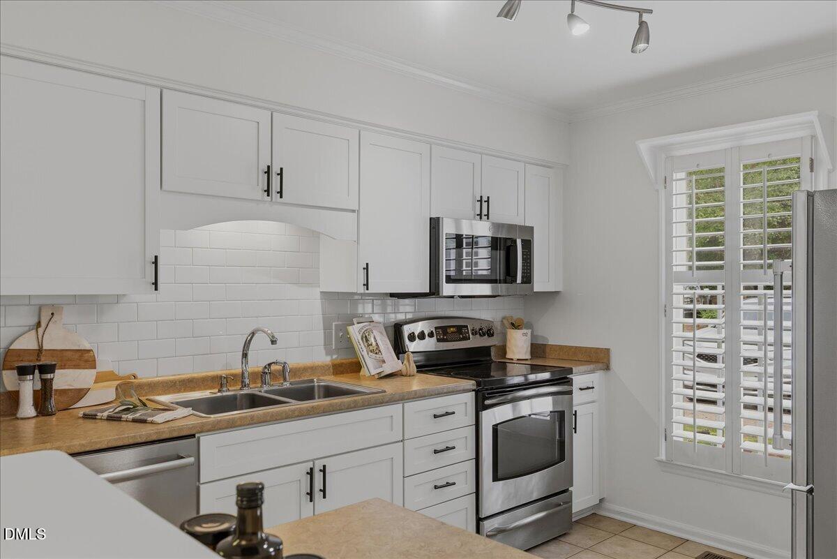 2834 Wayland Drive Raleigh, NC 27608 - Photo 6 of 26 a kitchen with appliances a sink and cabinets