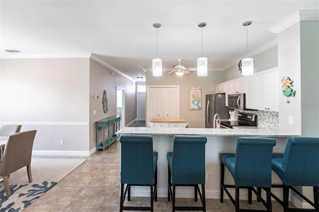 2002 Bal Harbor Boulevard, Unit 1022 Punta Gorda, FL 33950 - Photo 7 of 32 a kitchen with a dining table chairs and white cabinets
