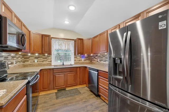 a kitchen with stainless steel appliances granite countertop a refrigerator and a stove top oven