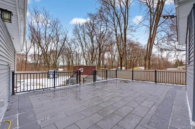 a view of backyard with a large trees and wooden fence