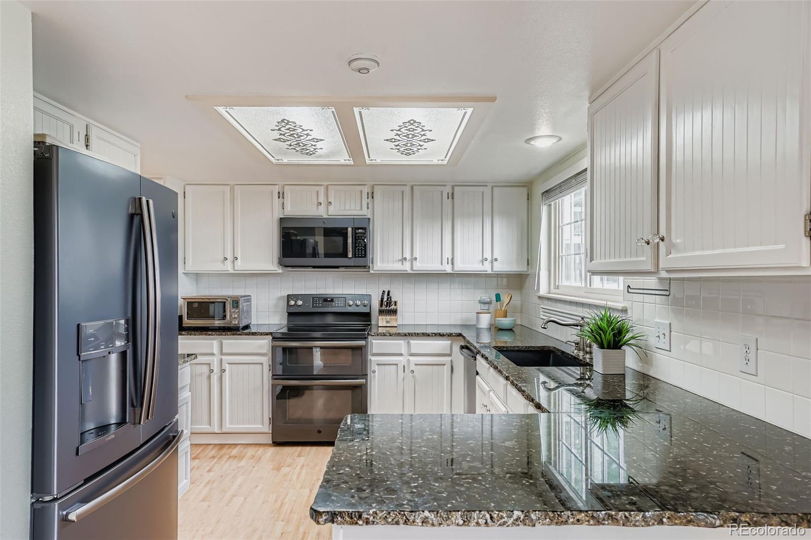 202 Northridge Road Highlands Ranch, CO 80126 - Photo 15 of 37 a kitchen with stainless steel appliances granite countertop a refrigerator a stove and a sink