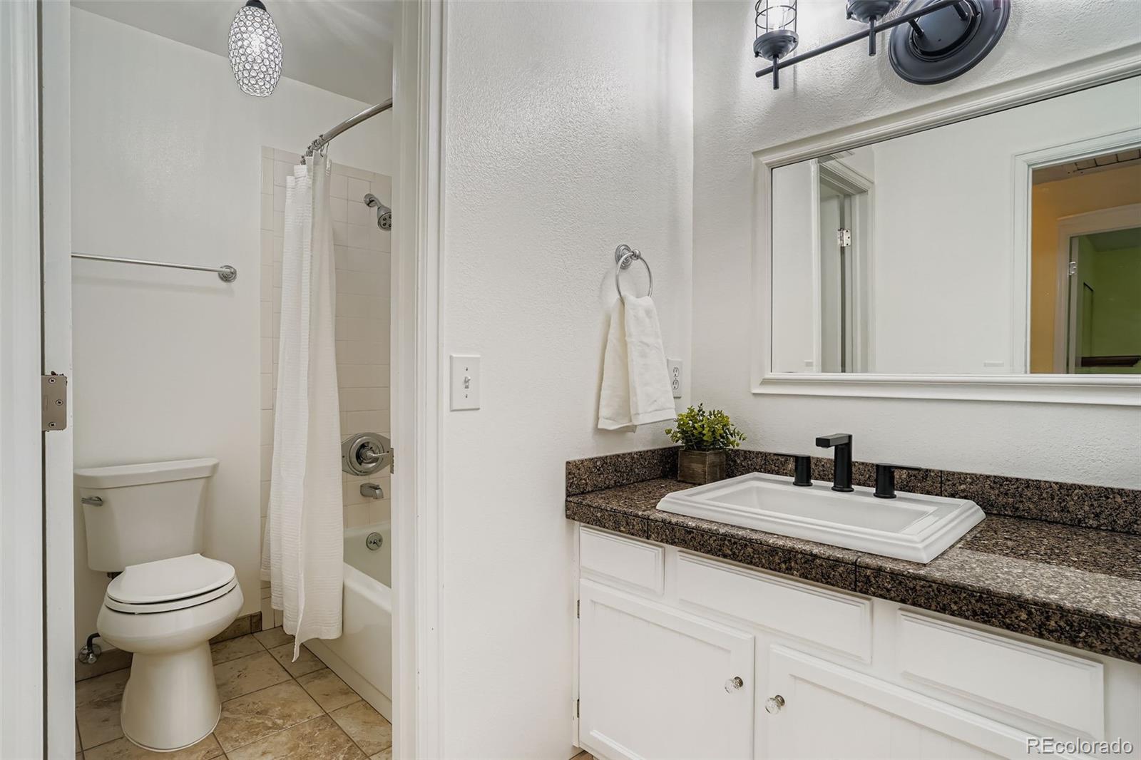 202 Northridge Road Highlands Ranch, CO 80126 - Photo 27 of 37 a bathroom with a granite countertop toilet sink and mirror