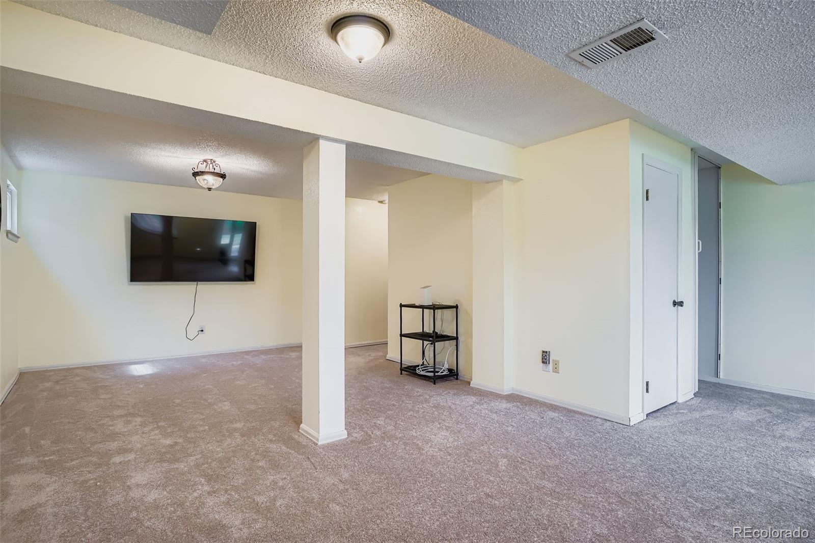 202 Northridge Road Highlands Ranch, CO 80126 - Photo 31 of 37 a living room with a flat screen tv and a projector