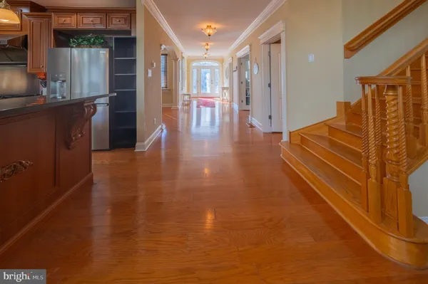 a view of a hallway with wooden floor and glass windows