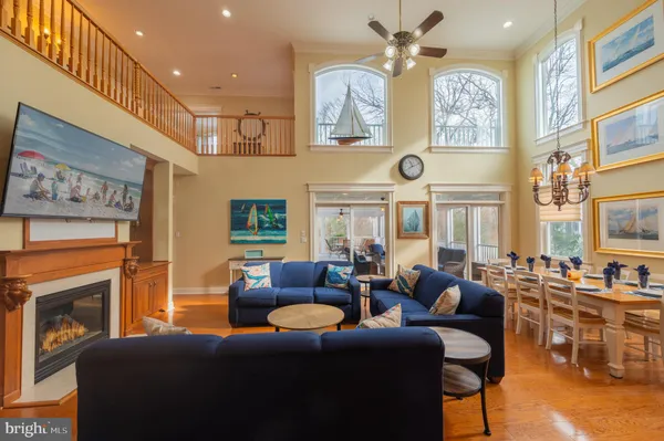 a living room with furniture with kitchen view and wooden floor