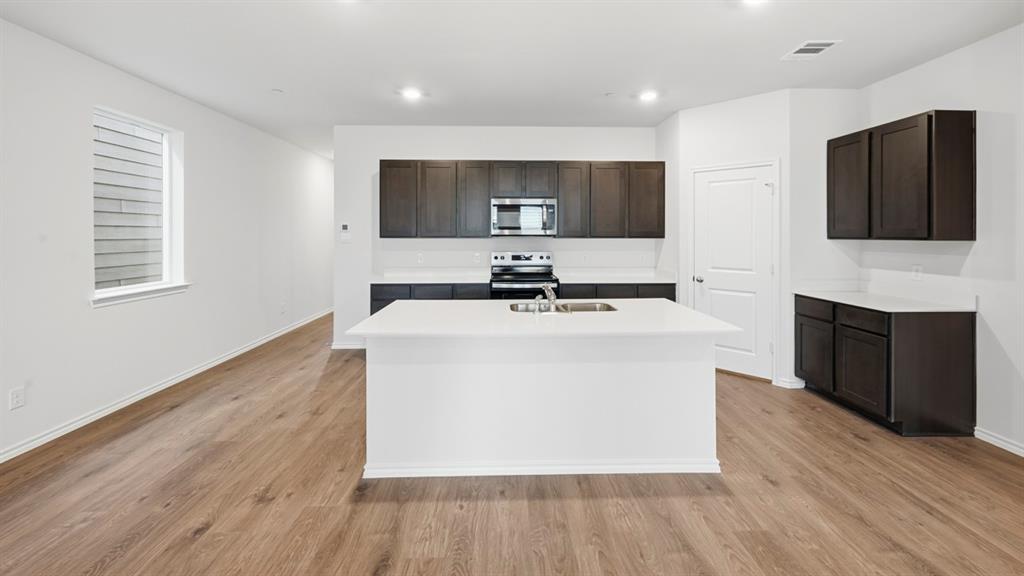 206 Redwood Road Princeton, TX 75407 - Photo 28 of 40 a room with a sink wooden floor and a fireplace
