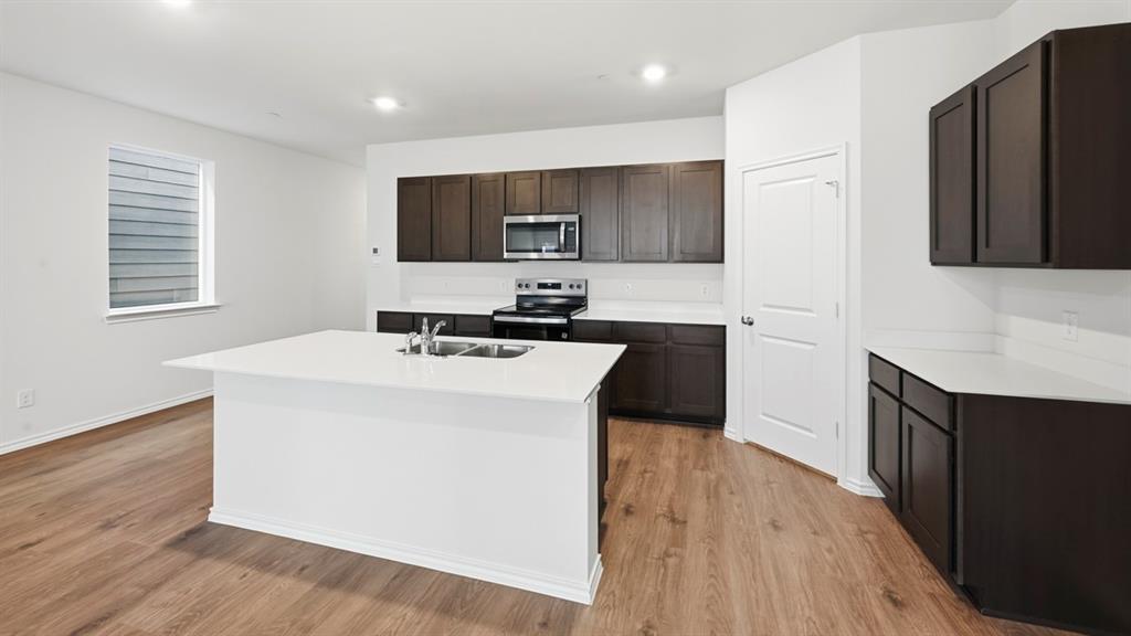 206 Redwood Road Princeton, TX 75407 - Photo 29 of 40 a kitchen with a sink a microwave and cabinets