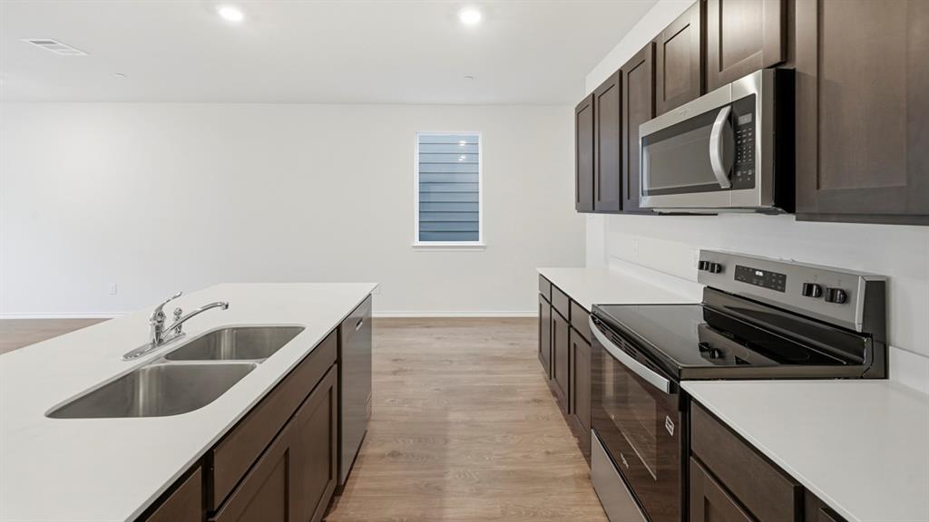206 Redwood Road Princeton, TX 75407 - Photo 31 of 40 a kitchen that has a sink and a stove